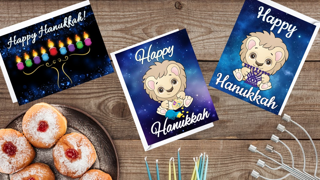 tabletop showing 3 different Hanukkah greeting cards, along with a plate of sufganiyot, candles, and a menorah