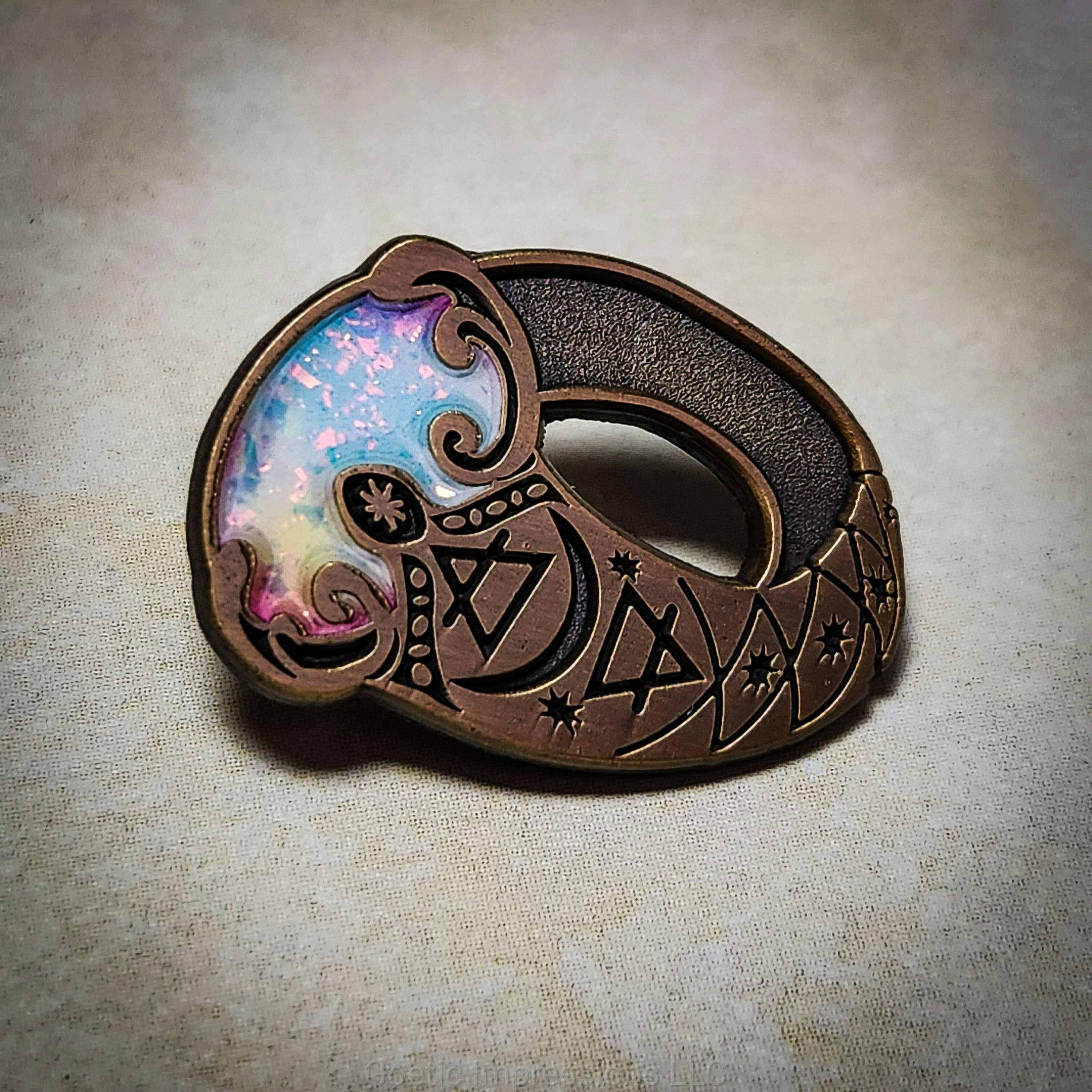 Antique gold stylized enamel pin with opal flakes and air and earth element sigils on it