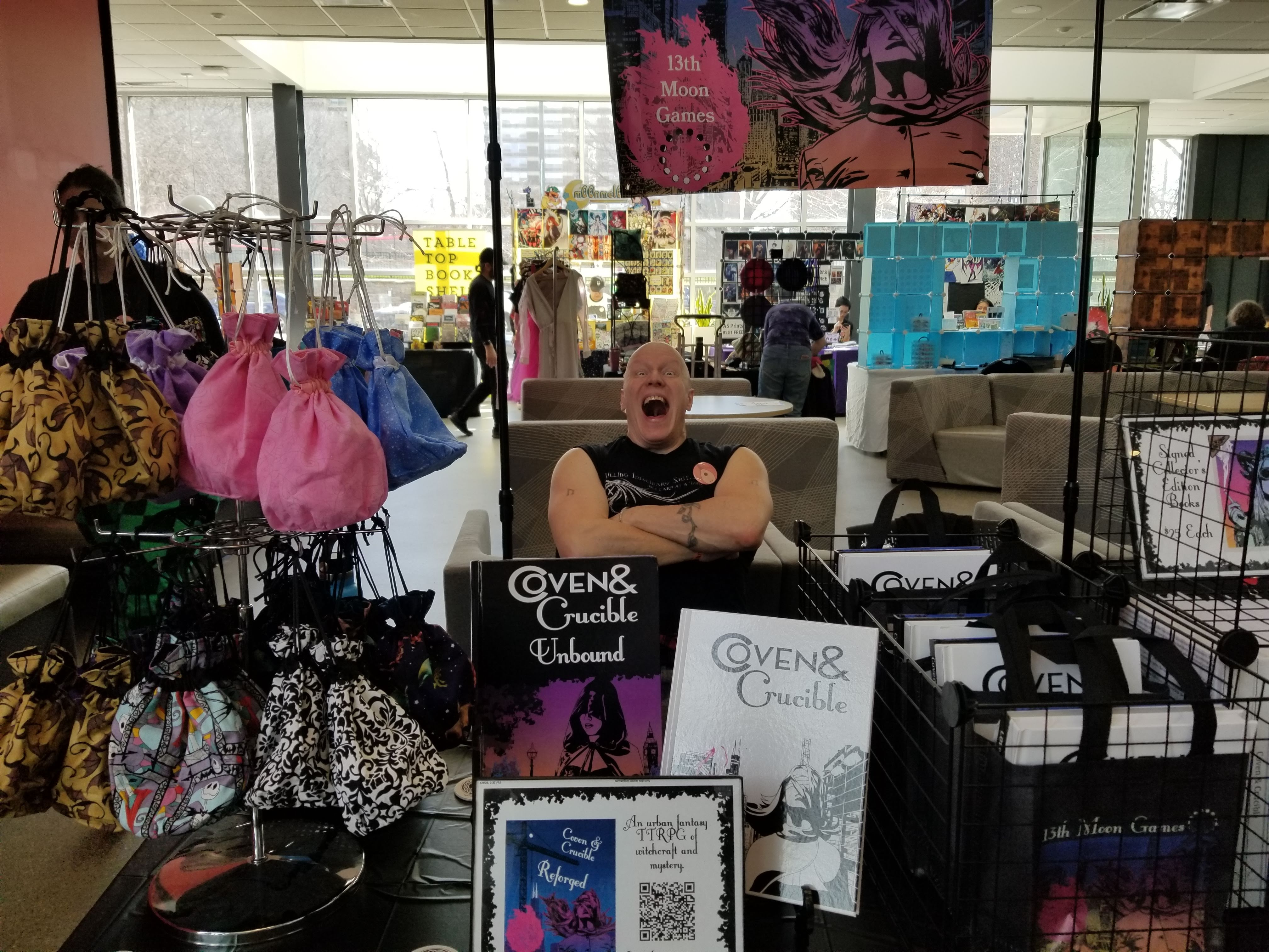 A photo of Stephan sitting at our booth looking like he is screaming and smiling at the same time.