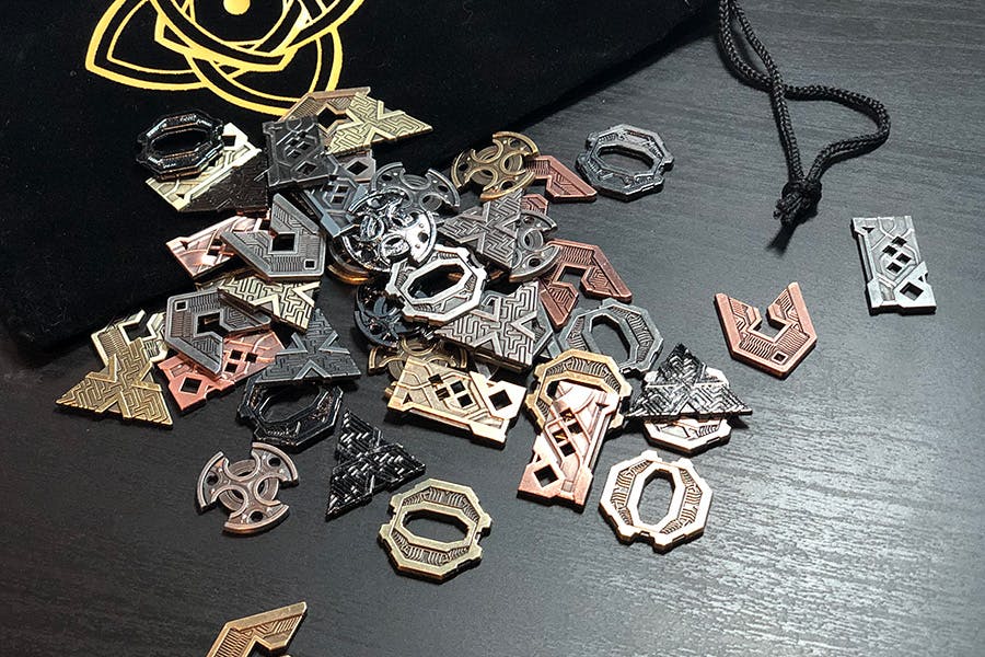 Image of dozens of shins—little bits of shiny fantasy tech items in a variety of shapes and sizes much like strange fantasy coins—spilling from a cloth bag.
