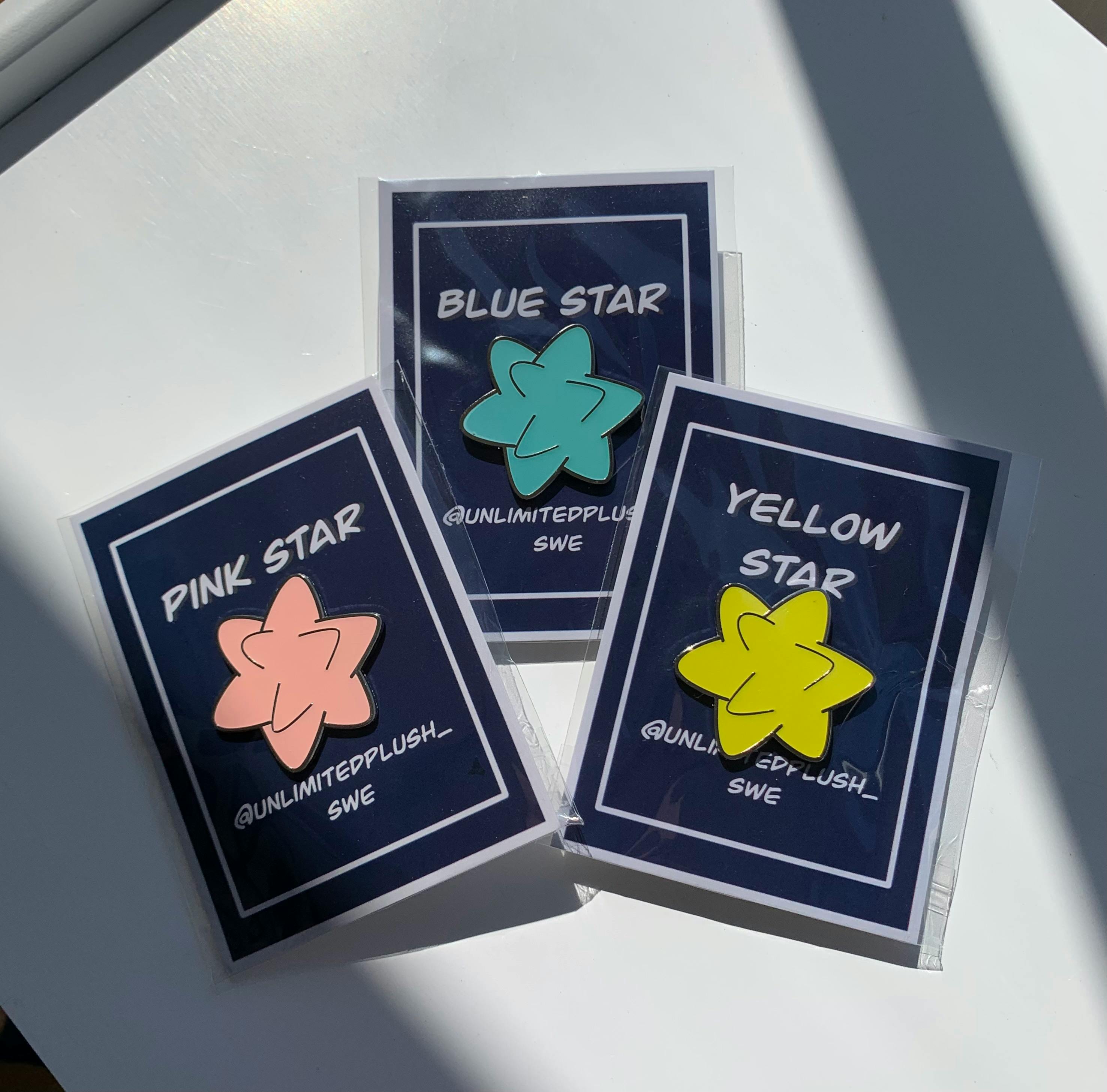 Three glow star pins blue, yellow and pink