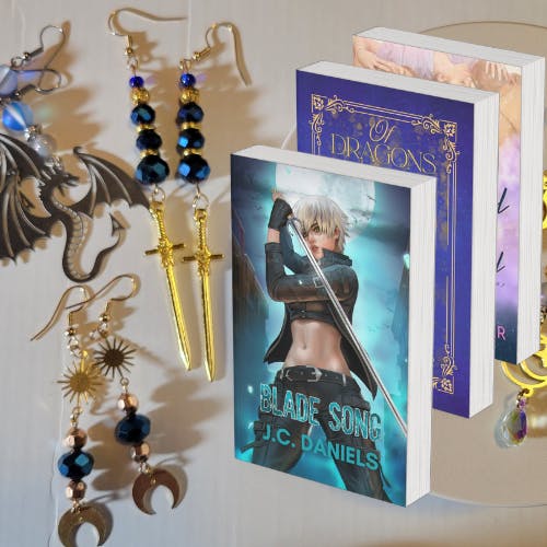 three pairs of earrings and mockups of Blade Song, Of Dragons & Fae and Kiss & Tell at the Wishing Well