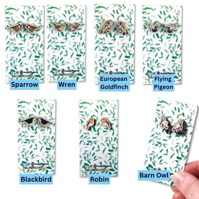 a group of seven pairs of wooden small stud earrings made from illustrations by Loadofolbobbins. Clockwise from top left they show sparrows, wrens, European goldfinches, flying pigeons, swooping barn owls, robins and male blackbirds.