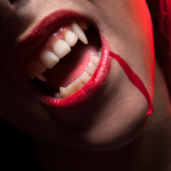 An enigmatic enby, their wicked smile just might be hiding fangs...