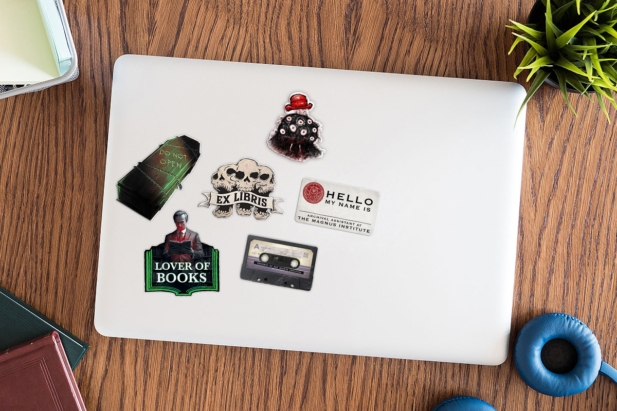 Image of a laptop with six stickers on it.