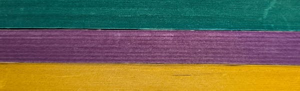  Super close up of the spray edges on three stacked paperbacks - green, purple, then yellow. 