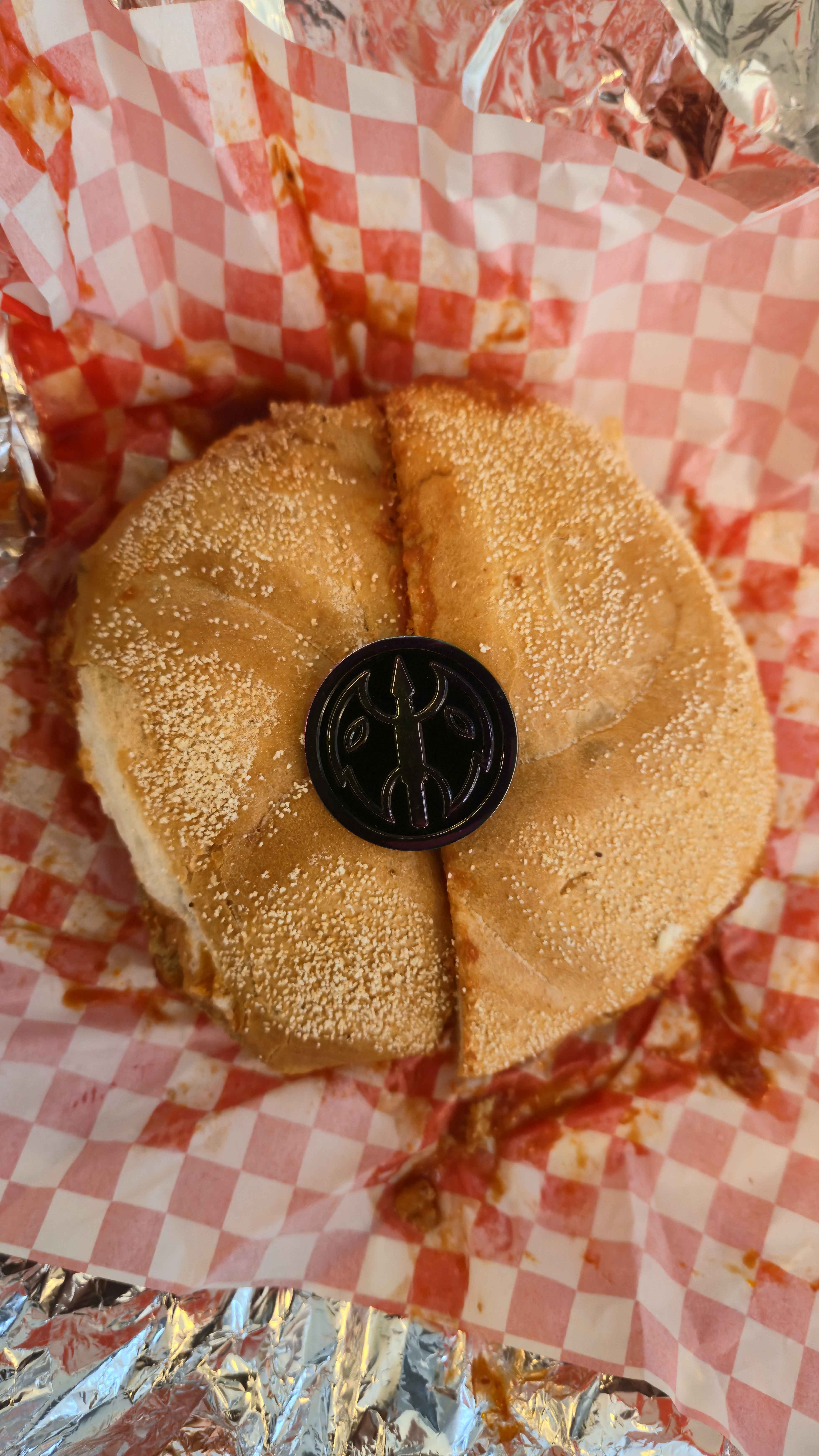  Picture of a BIG meatball sandwich with the NESS rainbow metal pin sitting dead in the center. 