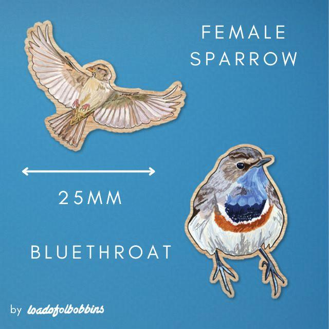 A mock up of two mini 25mm wooden bird pins made from original illustrations by Loadofolbobbins. They show a flying female house sparrow, with wings outstretched in a joyous free position. The other is of a bluethroat bird looking rather birb like and all round and pretty with stunning blue colouring under it's beak. 